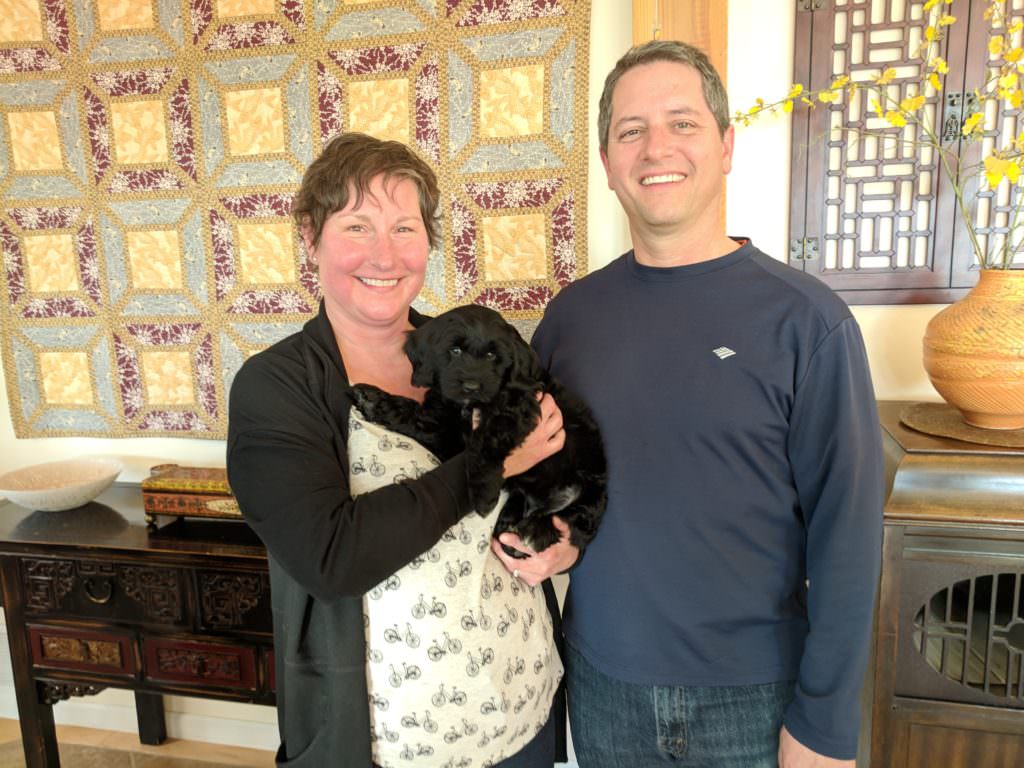 couple with their new labradoodle puppy