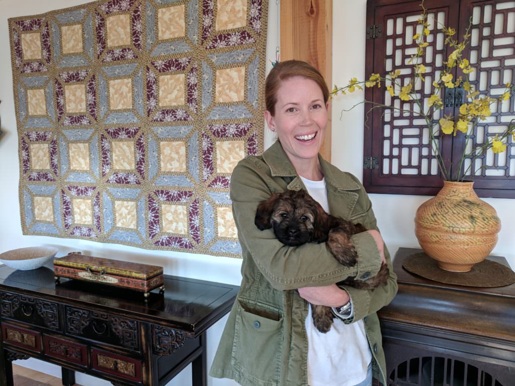 Woman holding labradoodle puppy