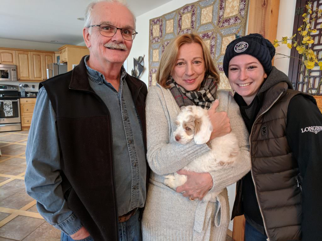 Couple with their young daughter and their new labradoodle puppy