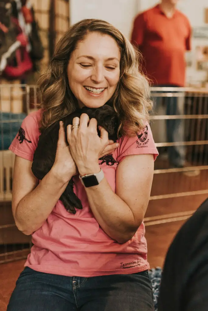 Labradoodle puppy being hugged by new "mom"